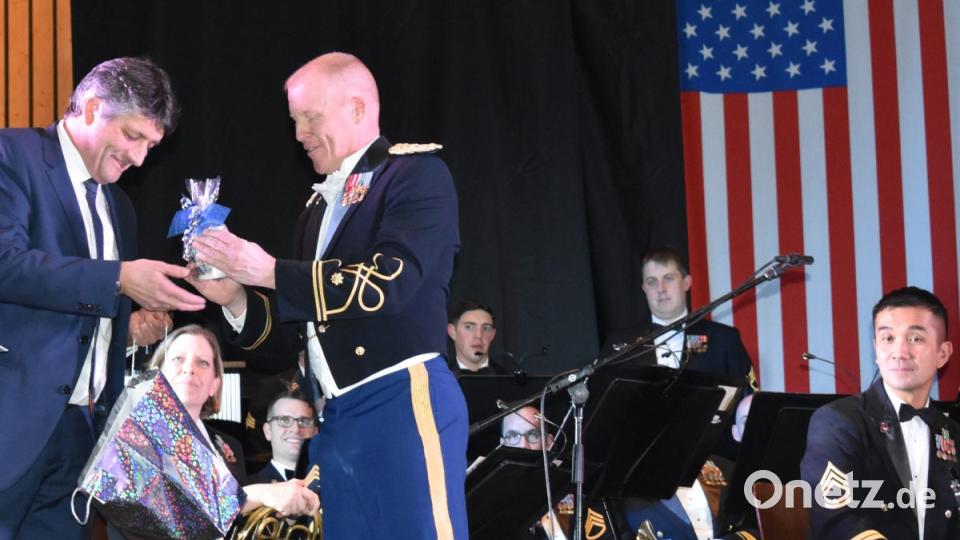 Bürgermeister Edgar Knobloch (links) überreicht die Grafenwöhr-Tasse, Taufwein vlon der Partnergemeinde aus Österreich sowie das Truppenübungsplatz-Buch von Gerald Morgenstern an den Leiter der USAREUR-Band Major Randall Bartel . Bild: rgr