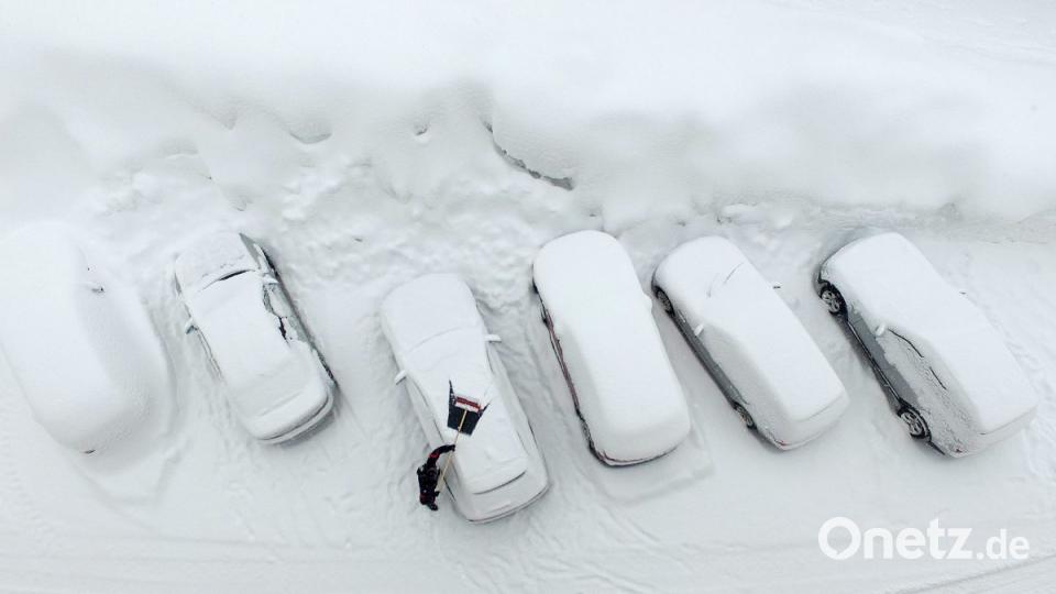 Ein Mann befreit sein Auto von Schnee. In weiten Teilen Österreichs sind in den letzten Tagen erhebliche Mengen an Schnee gefallen. Bild: Helmut Fohringer/APA/dpa