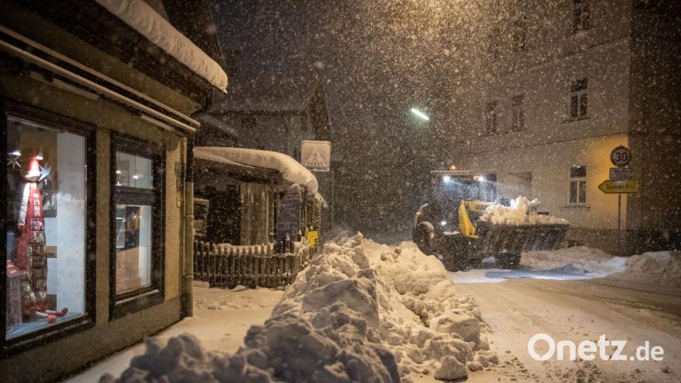 Ein Radlader fährt in Miesbach neben aufgetürmtem Schnee durch die Innenstadt von Miesbach. Der Landkreis Miesbach hat wegen starken Schneefalls und Unwetter einen Katastrophenalarm ausgelöst. Bild: Lino Mirgeler/dpa