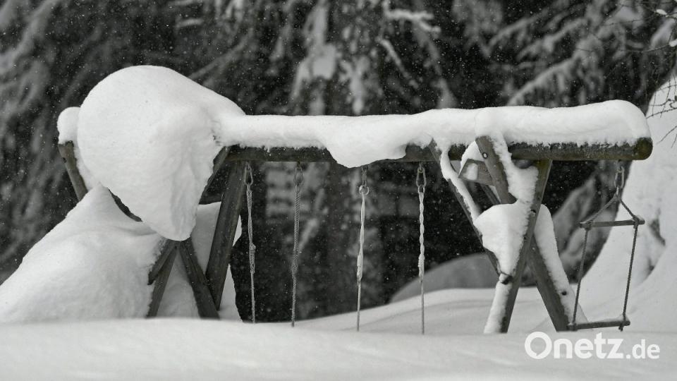 Eine Schaukel ist auf einem Kinderspielplatz im österreichischen Ramsau tief eingeschneit. Bild:  Harald Schneider/APA/dp