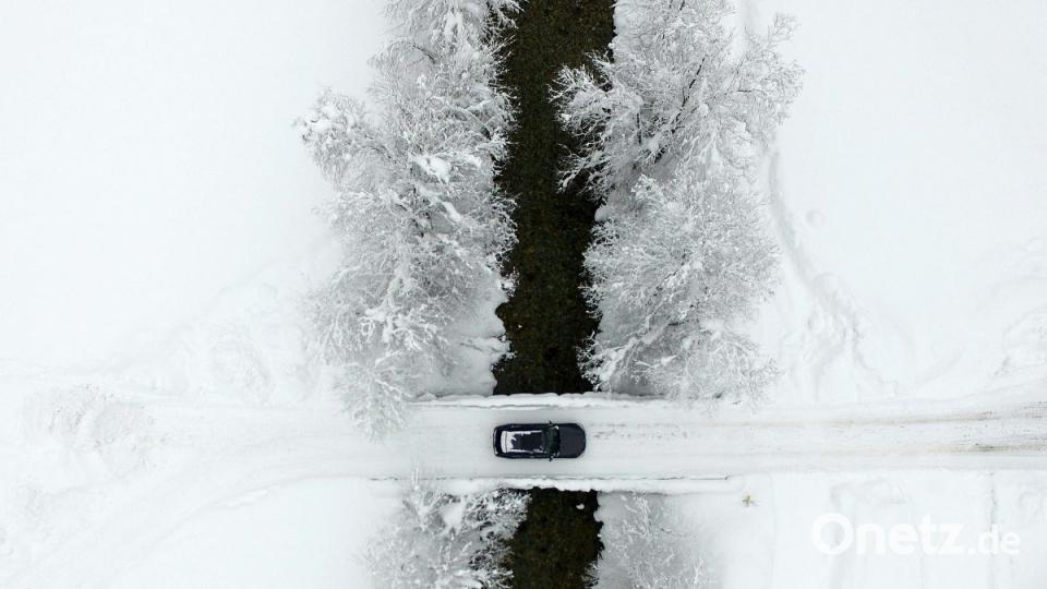 Ein Auto überquert eine verschneite Brücke in der Nähe von Untertauern in Österreich. Bild: Helmut Fohringer/APA/dpa