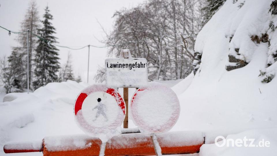 Ein Schild weist am Spitzingsee an einer Wegsperre auf eine Lawinengefahr hin. Bild: Lino Mirgeler/dpa