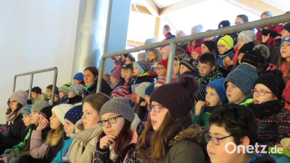 Die Schul- und Kindergartenkinder schauan aufmerksam nach vorne auf die Eisfläche, wo Peter Pan auf dem Eis seine Abenteuer erlebt. Bild: ubb