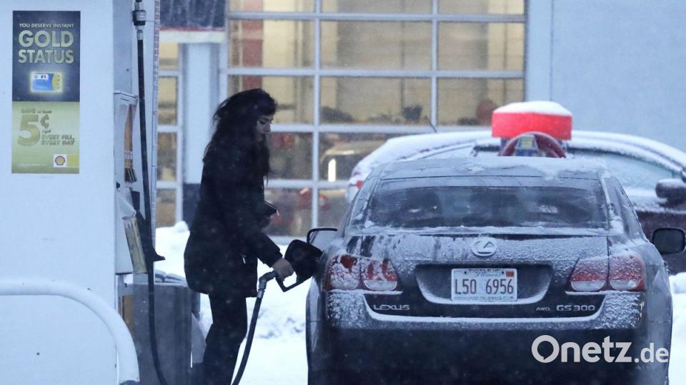 Eine Frau tankte ihr Auto an einer Tankstelle. Auf ein kaltes Wochenendwetter folgte ein Sturm, der mehr als 15 Zentimeter Schnee auf dem Boden zurückließ. Bild: Nam Y. Huh