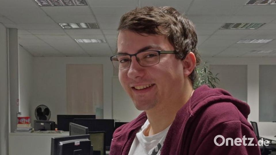 Korbinian Eckert mit seiner Kameraausrüstung. Auf dem Tisch sind zwei Kalender von ihm zu sehen. Bild: tr