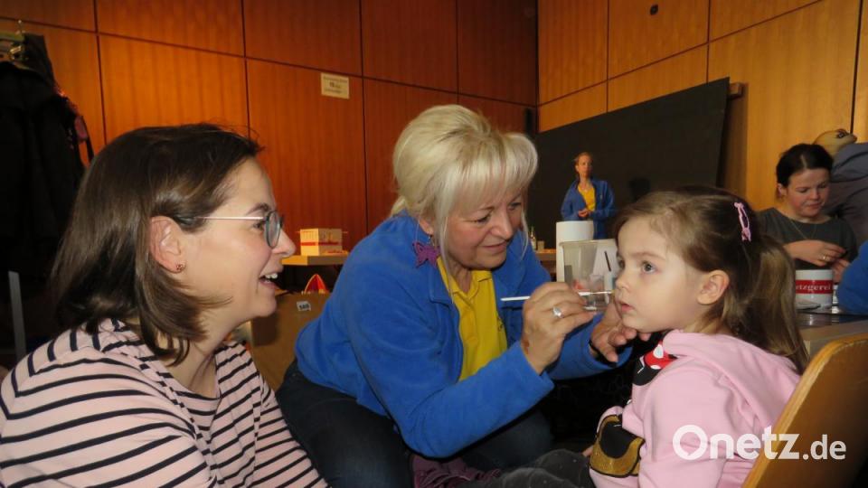 Kindergartenleiterin Silvia Markowski (Mitte, beim Schminken der zweijährigen Anna mit deren Mutter) hat Hugo versprochen, dass er regelmäßig Nachricht per WhatsApp oder Brief von seinen Freunden aus dem Städtischen Kindergarten bekommt. Bild: ubb