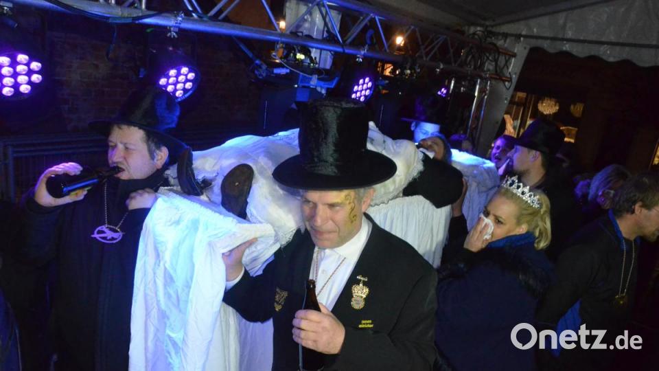 Er hatte ein langes Leben. Fast vier Monate dauerte der Fasching. Jetzt wurde er dahingerafft. Am Faschingsdienstag nach Einbruch der Dunkelheit – Johnny Gold hatte sich gerade verabschiedet – zog die Trauergemeinde der Narrhalla Weiden vor das Alte Rathaus und bejammerte seinen Prinzen Georg I., dessen Regentschaft beendet wurde. Vor allem Prinzessin Patricia I. war tief betroffen vom Verlust. Die Trauergemeinde spülte ihren Kummer mit Bier herunter. Und mit Bier wurde auch der Prinz auf der Bahre begossen. Bild: Kunz
