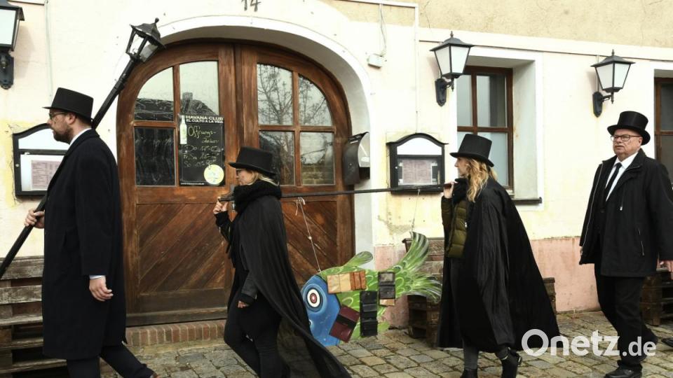 Die schwarz gekleidete Schar begibt sich in langer Reihe auf den Marsch durch die Wirtshäuser. Bild: Petra Hartl