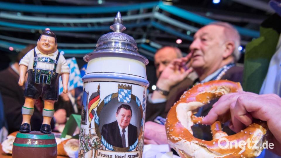 Eine Figur von Franz Josef Strauß, ehemaliger Ministerpräsident von Bayern, steht beim politischen Aschermittwoch der CSU in Passau in der Dreiländerhalle neben einem Bierkrug mit seinem Konterfei. Bild: Peter Kneffel/dpa
