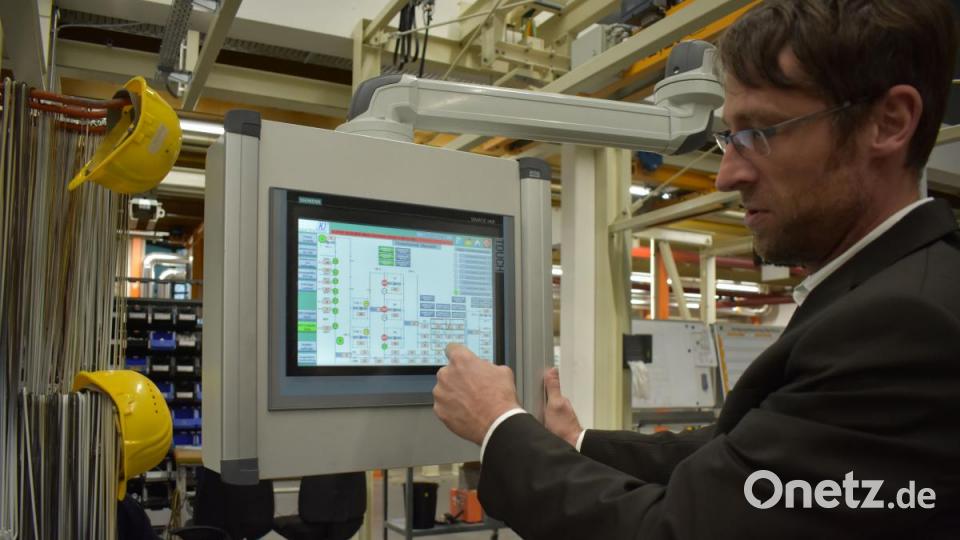 Der Abteilungsleiter für Oberflächentechnik Frank Pecher zeigt, wie die neue intelligente Steuerung der Lackiereiei bei Siemens Healthineers funktioniert. Über einen Touchscreen erkennt er schnell, den aktuellen Stand in der Produktion. Bild: lue