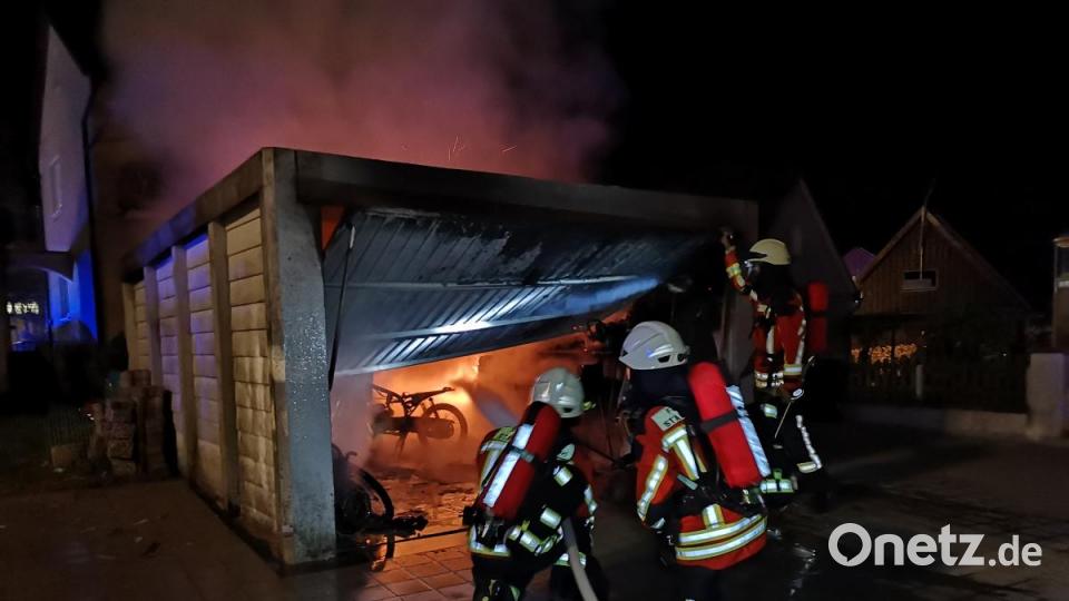 Atemschutzkräfte der Kemnather Feuerwehr löschen den Garagenbrand, welcher sich am späten Freitagabend im Kemnather Ortsteil Fortschau ereignete. Feuerschein erhellte den Nachthimmel. Bild: mde