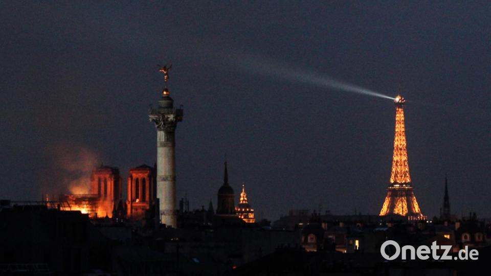 Feuerschein erhellt die Pariser Kathedrale Notre-Dame (links). In der weltberühmten Kathedrale Notre-Dame in Paris war am Montagabend ein Feuer ausgebrochen. Über dem Wahrzeichen waren Flammen und eine riesige Rauchsäule zu sehen. Ein kleiner Spitzturm in der Mitte des Daches stürzte ein. Bild: dpa/Matthias Wagner
