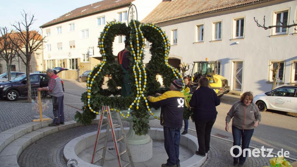 Mitglieder des Gartenbauvereins halfen zusammen, um dem "Geist-Brunnen" im Ortskern von Schönsee die Osterkrone aufzusetzen. Bild: mmj