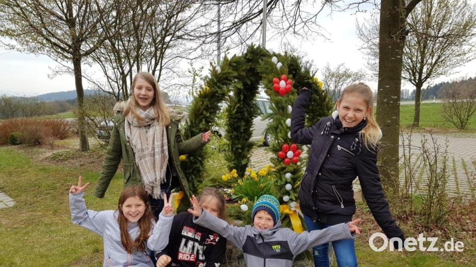 Der Osterbrunnen in Irlach wurde heuer an einem neuen Standort aufgestellt. Auch den Kindern gefällt das sichtlich gelungene Gemeinschaftswerk. Bild: ad
