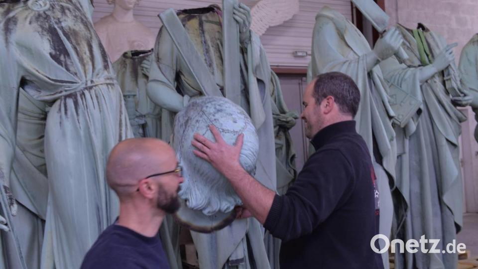 Zwei Mitarbeiter der SOCRA legen Hand an an den Statuen aus Notre Dame de Paris. Bild:  Stephane Klein/ Sud Ouest