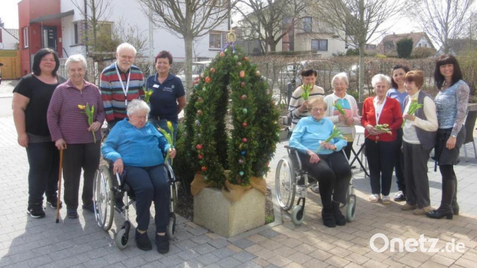 Heimleiterin Annett Schmerbauch (rechts) freut sich mit den Bewohnern des Evergreen-Hauses in Schnaittenbach über den schön geschmückten Osterbrunnen am Hauseingang. Bild: exb