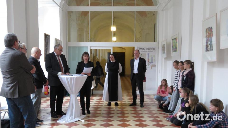 Bei der Vernissage las Künstlerin Ursula Wohlfeld (am Tisch) von der Kulturverwaltung des Bezirks Oberpfalz einen lyrischen Beitrag einer Ausstgellungsteilnehmerin vor. Auch einige Schülerinnen der Mädchenrealschule schauten sich die Ausstellung an, was den Bezirkstagvizepräsident Lothar Höher (li. am Tisch) sehr freute. Bild: ubb
