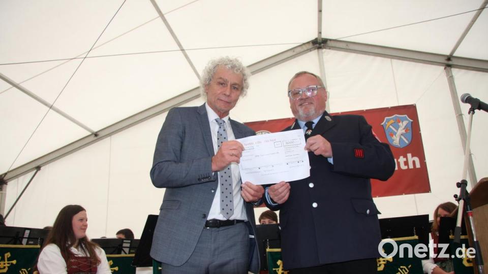 1000 Euro in Form eines großen Schecks hatte Landrat Wolfgang Lippert (links) mitgebracht, den er Vorsitzenden Raimund Hofmann in die Hand drückte. Bild: wro