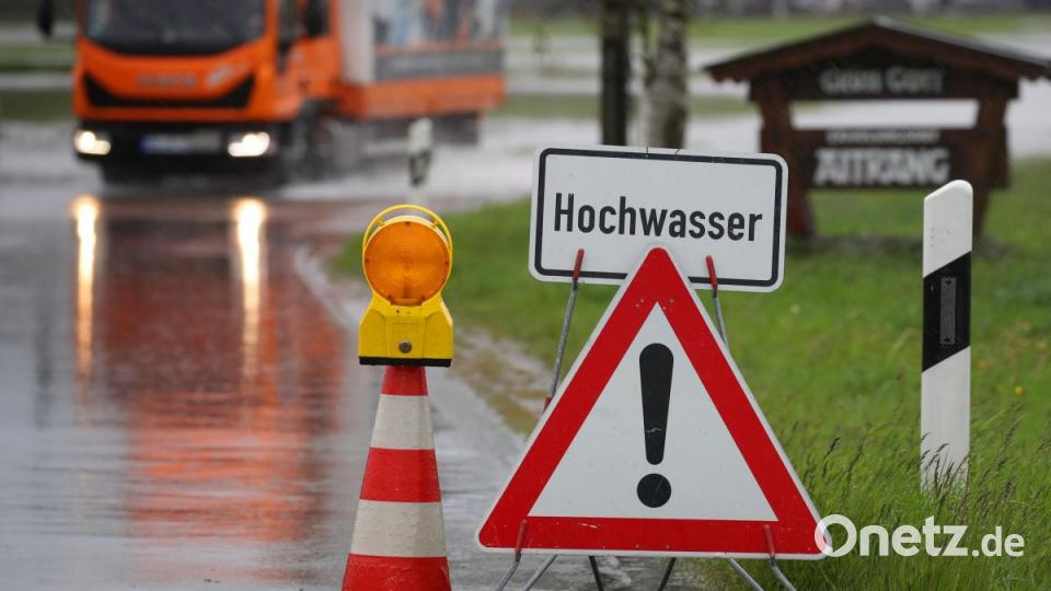 Eine Straße in Bayern ist vom Wasser eines über die Ufer getretenen kleinen Baches überschwemmt. Bild: Karl-Josef Hildenbrand
