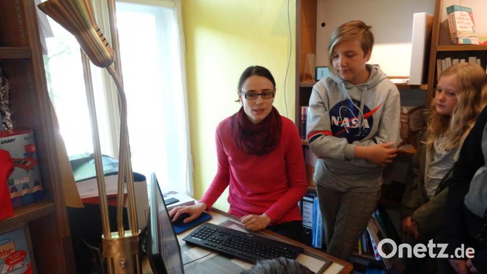 Adele Herrmann, Mitarbeiterin in der Buchhandlung Dorner, macht die jungen Gäste am PC mit dem Bestellsystem bekannt. Bild: hka