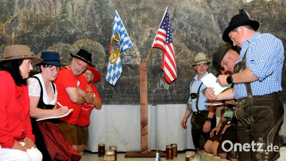 Überraschung für die amerikanischen Freunde: Sie bekamen nach dem offiziellen Teil gleich einen sehr praxisnahen Einblick in die Oberpfälzer Kultur – beim Patenbitten, natürlich mit Holzscheitl-Knien, wie es Brauch ist im Landkreis. Bild: Stephan Huber