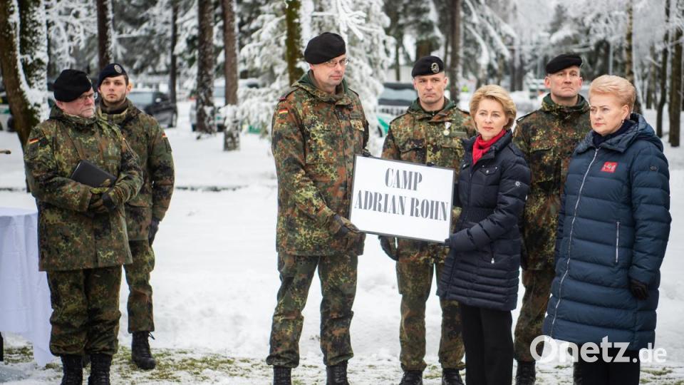 Oberstleutnant Peter Papenbroock (Mitte), Oberstleutnant René Braun (Vierter von rechts), Bundesverteidigungsminsiterin Ursula von der Leyen (CDU) und die litauische Präsidentin Dalia Grybauskaite (rechts) halten in Rukla, Litauen, ein Schild mit der Aufschrift &quot;Camp Adrian Rohn&quot;. Sie gedenken des deutschen Soldaten, der hier im Jahr 2018 bei einer Übung ums Leben kam. Bild:  Arne Bänsch/dpa