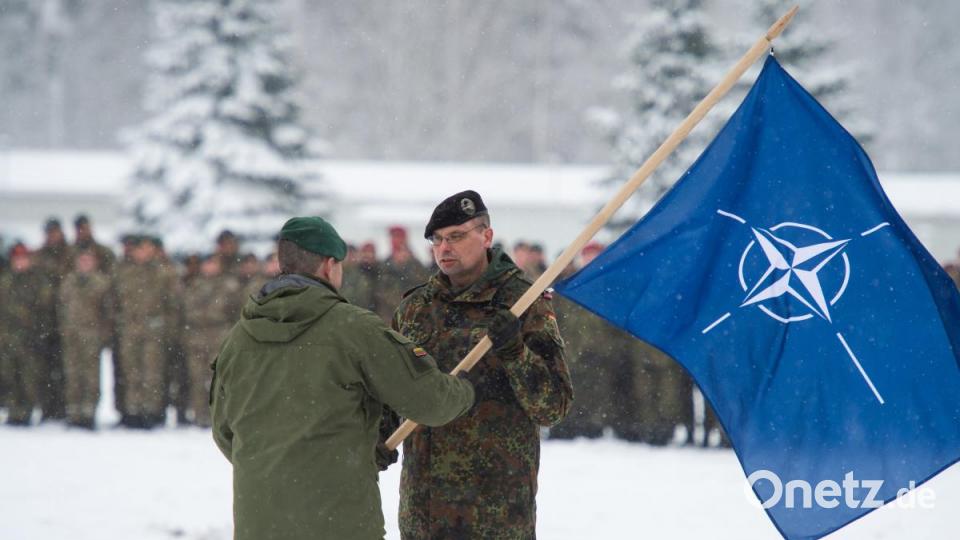 Der Kommandeur der litauischen Brigade „Iron Wolf“ Steponauvicius Mindaugas (links) reicht beim Übergabeappell feierlich die Nato-Flagge an Oberstleutnant Peer Papenbroock aus Pfreimd (Kreis Schwandorf) weiter. Der Kommandeur des Panzerbataillons 104 führt nun die EFP-Battlegroup in Litauen. Bild: Arne Bänsch/dpa