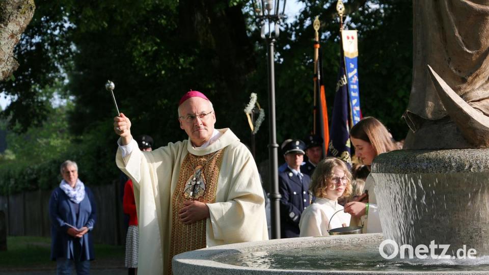 Bischof Rudolf Voderholzer bespritzt den Marienbrunnen mit Weihwasser. Bild: bsc