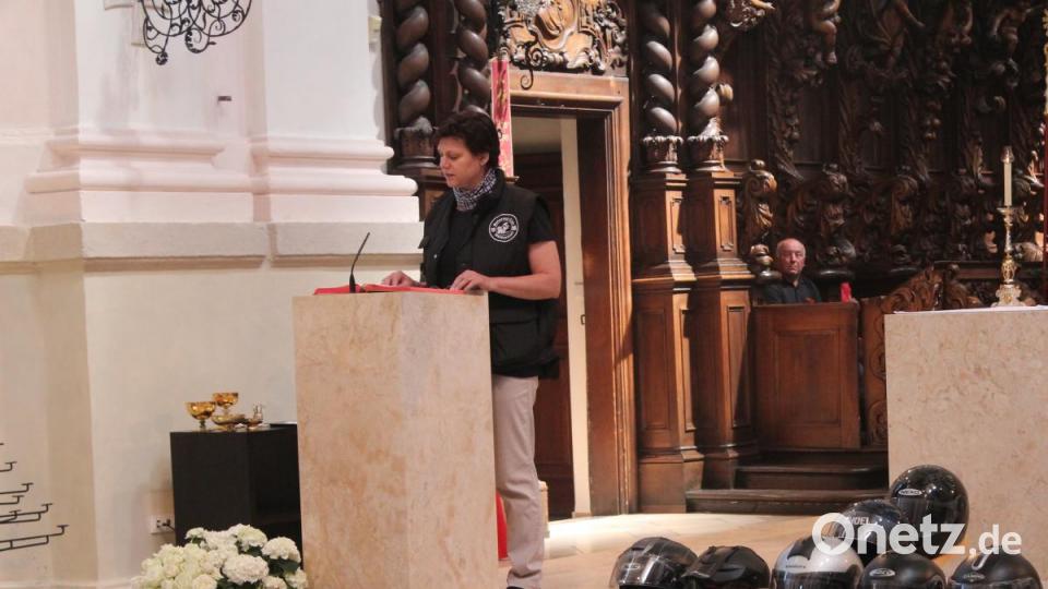 Elisabeth Schröpf trug die Lesung vor. Vor dem Altar Motorradhelme, die kreuzförmig angeordnet sind. Bild: Susanne Forster