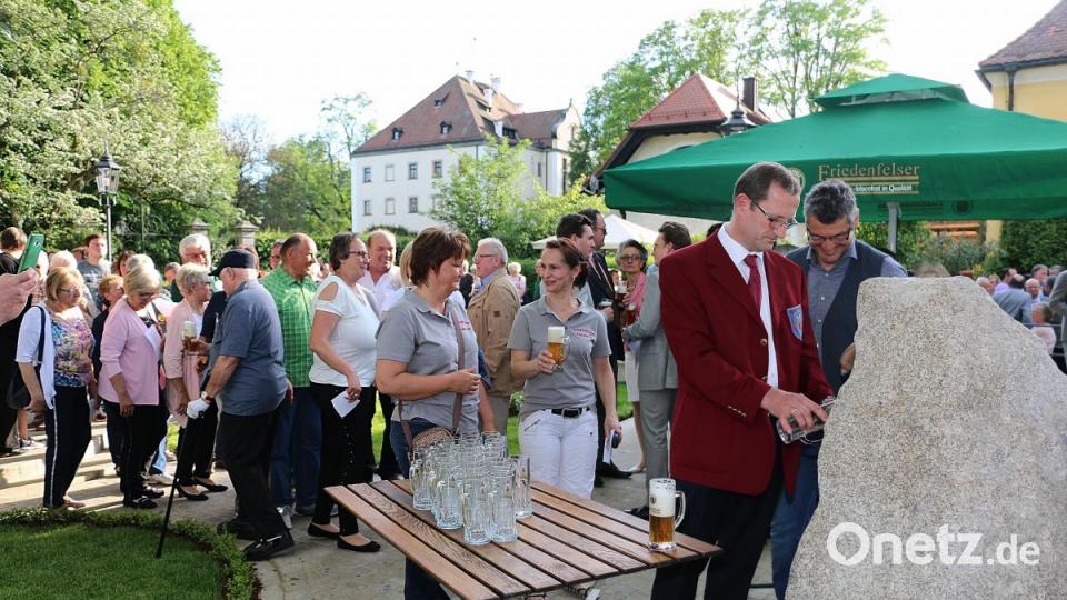 Braumeister Christian Mitterbauer und Uwe Heider (vorne von links) ließen nach der Weihe des Marienbrunnens Bier aus einem Stein fließen. Künftig können Wanderer hier per Knopfdruck frisches Trinkwasser zapfen. Bild: bsc