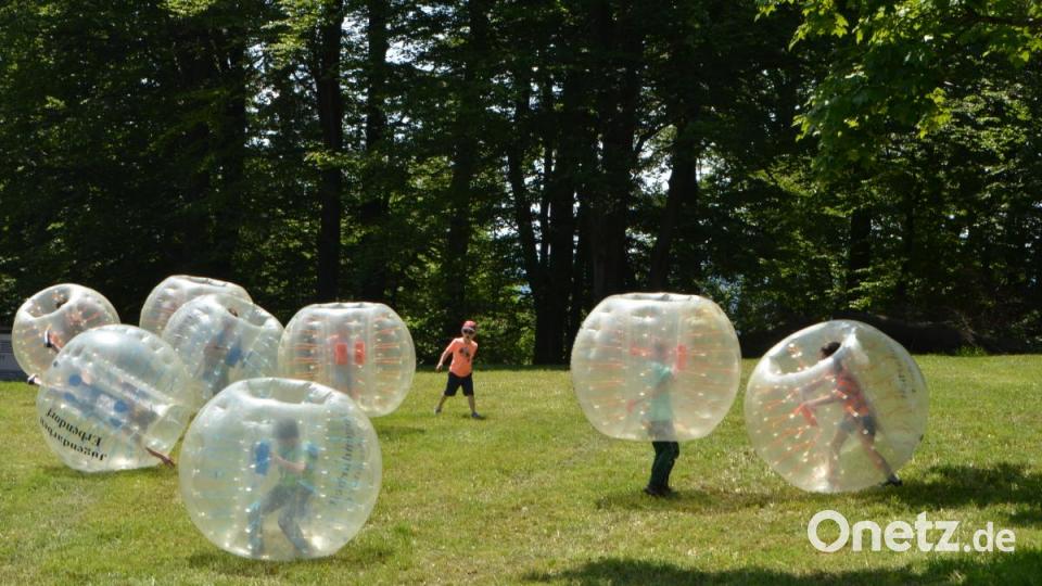 Jede Menge Spaß ist für die Kinder angesagt, die sich mit „Bubble-Soccer-Bällen“ auf der Wiese hinter der Wallfahrtskirche austoben können, während sich die Erwachsenen an den Tischen unterhalten. Bild: dob