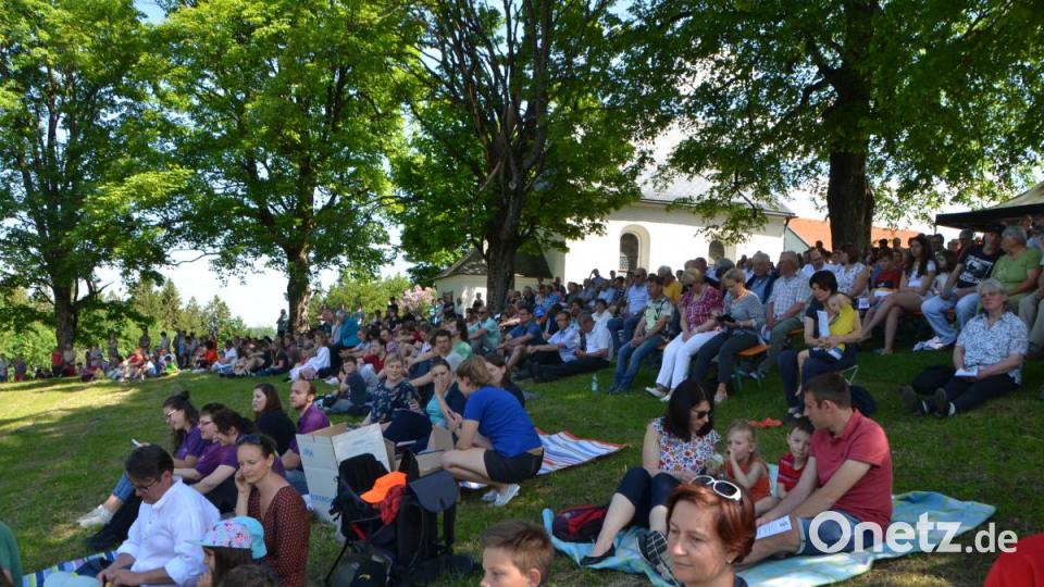 Zum Open-Air-Gottesdienst auf dem Hügel lasssen sich die Besucher unter dem Schatten der Bäume nieder. Bild: dob
