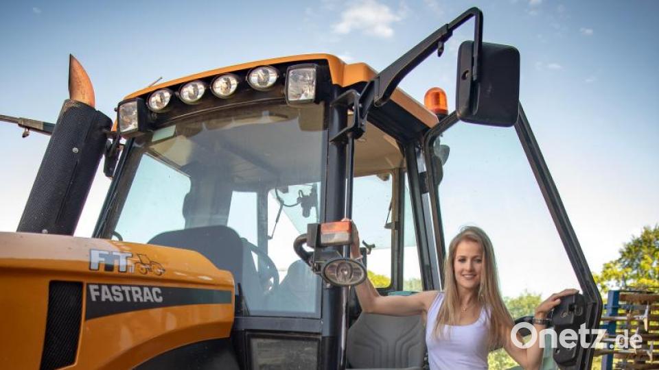 Daniela, Model, für den Jungbäuerinnenkalender 2020, steht auf einem Traktor. Bild: Sina Schuldt/dpa