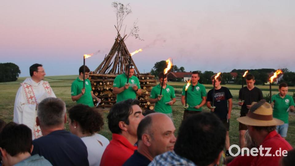 Die Jugendlichen aus Ursulapoppenricht lesen Fürbitten vor dem Entzünden des Johannisfeuers mit Pfarrvikar Christian Preitschaft (links). Bild: Nicole Koller