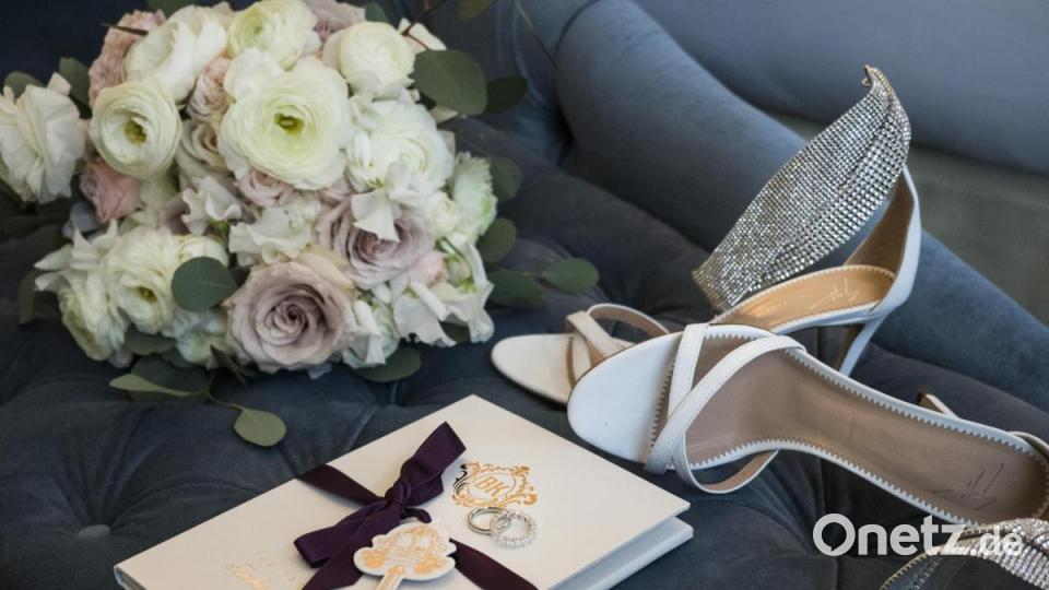 &quot;BK&quot; steht auf dem Büchlein mit der violetten Schleife - die Initialen der Vornamen des Brautpaares. Daneben liegen der Brautstrauß und die Schuhe der Braut. Bild: Chris Singer