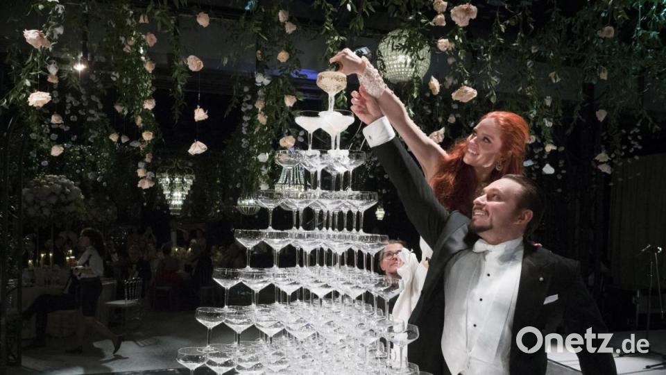 Jetzt darf angestoßen werden: Das Brautpaar befüllte die Champagner-Gläser und jeder Gast durfte sich eines nehmen - aber nicht von unten. Bild: Chris Singer