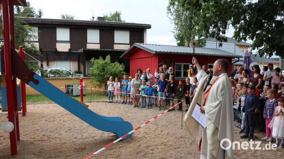 Pfarrer Heribert Stretz spendet den Segen für das neue Spielgerät. Bild: rpp