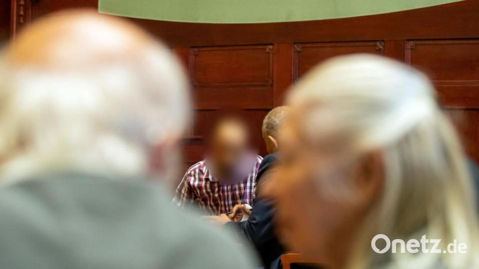 Ein wegen Mordes angeklagter Marokkaner (Mitte) sitzt vor Prozessbeginn im Sitzungssaal im Landgericht Bayreuth. Im Vordergrund sitzen die Eltern des Opfers. Bild: Daniel Karmann/dpa