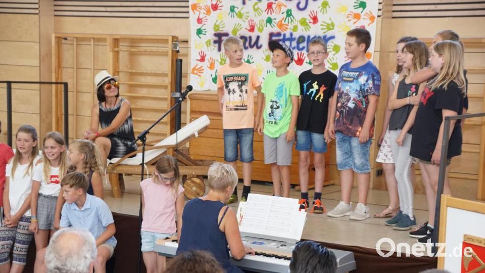 Zum Abschiedslied „Pädagogin aus Passion“ gibt es für Lucia Etterer (mit Hut) noch eine Liege zum Entspannen im Sonnenschein. Das Stück begleitet Rektorin Gudrun Lehner am E-Piano. Bild: bkr