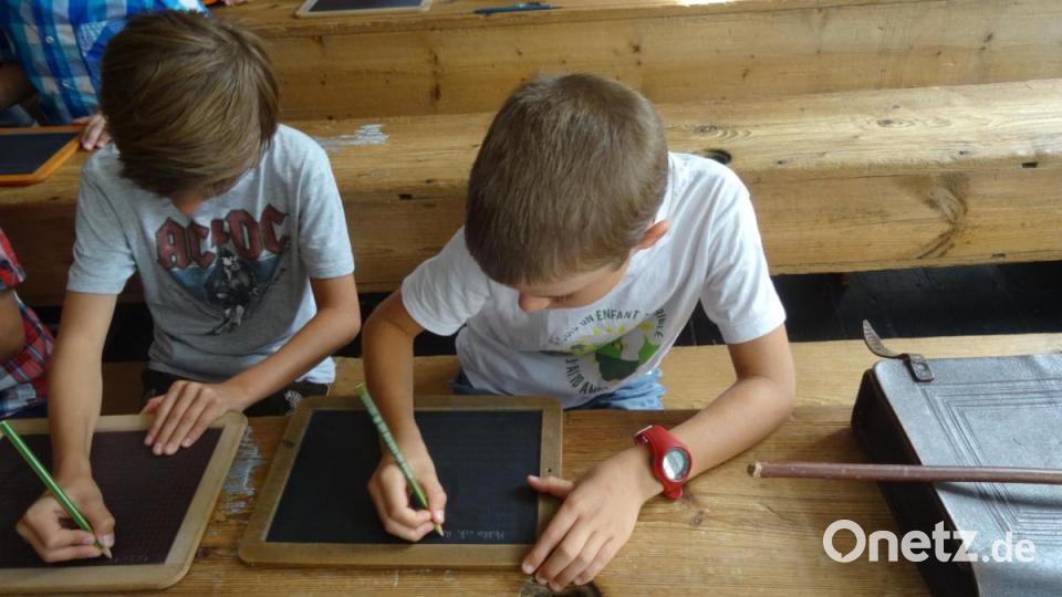 Keine leichte Aufgabe für Julian (links) und Guilherme: Mit einem Griffel altdeutsche Buchstaben schreiben. Bild: hka