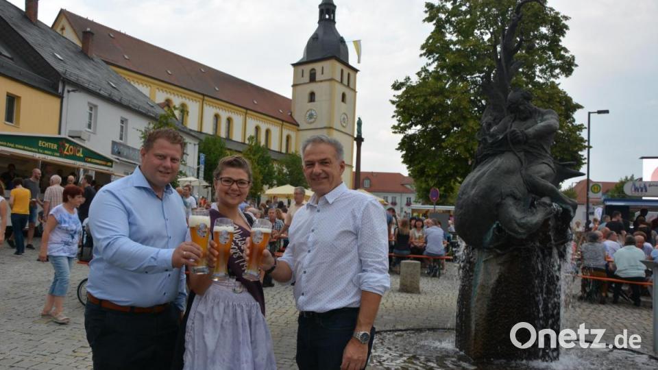 Stoßen auf ein überragendes Marktplatzfest an, Gewerbefördervereinsvorsitzender Stefan Grillmeier, Weißbier-Resi Martina Bleistein und Bürgermeister Roland Grillmeier (von links) haben sich dazu ein Weißbier genehmigt Bild: jr