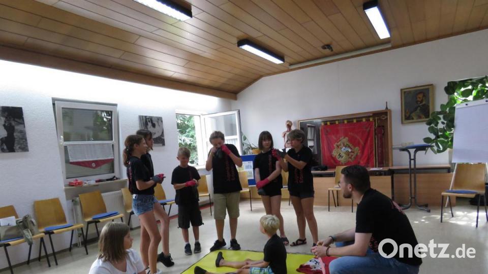 Gruppenleiter Sven Lehner (rechts) erklärt die Aufgabe: Ein Junge hat sich die Knie verletzt, ein Mädchen braucht einen Kopfverband. Bild: ubb