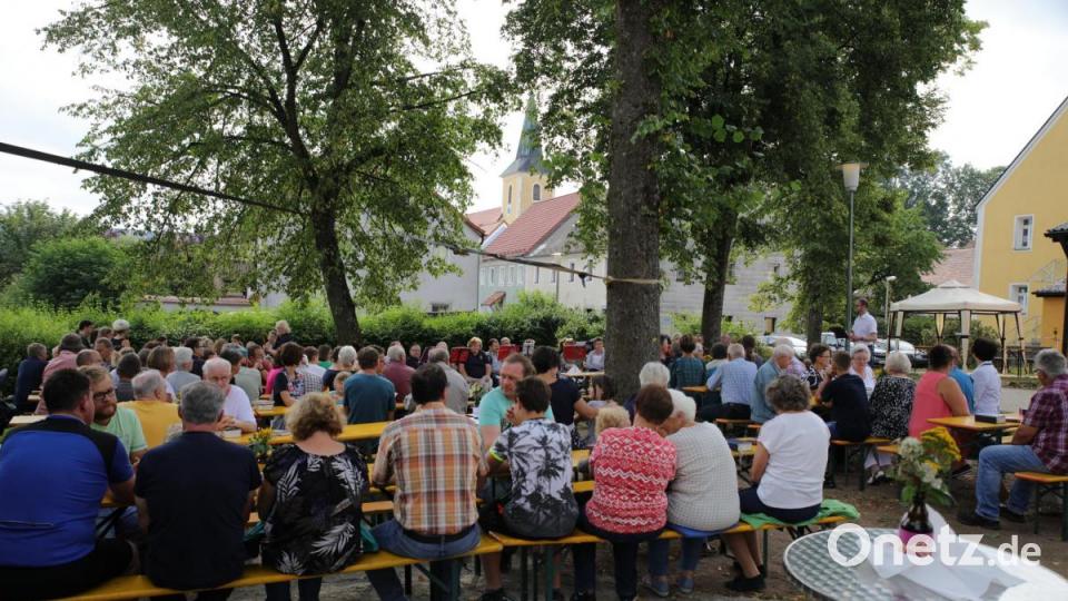 Pfarrer Manuel Sauer (stehend) bei der Andacht auf dem Dorfplatz. Bild: njn