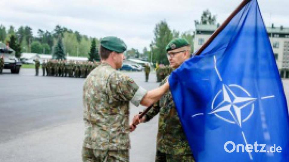 Der Kommandeur der litauischen „Iron Wolf&quot;-Brigade, Oberst Mindaugas Steponavicius, überreicht Oberstleutnant Rouven Habel aus Bad Salzungen (von links) die Truppenfahne. Bild: Virginijus Stonys/Iron Wolf Brigade/Verteidigungsministerium Litauen