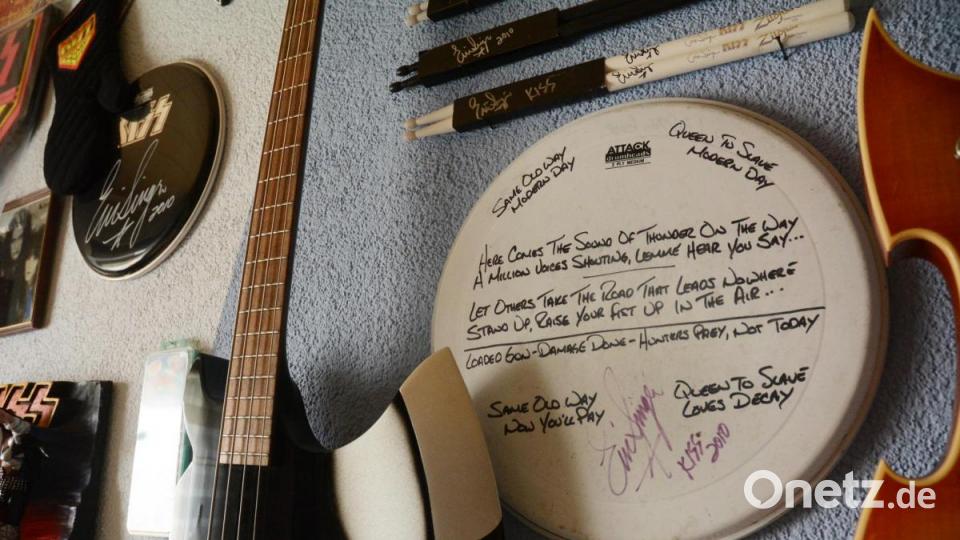 Ein von Eric Singer beschriftetes und signiertes Trommelfell, daneben ein Axt-Bass, wie ihn Gene Simmons spielt. Bild: Gabi Schönberger