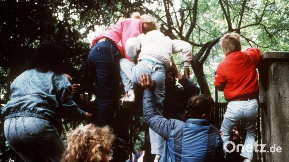 DDR-Bürger klettern am 29 September 1989 mit ihren Kindern über den Zaun der bundesdeutschen Botschaft in Prag. Archivbild:  Kemmether/dpa