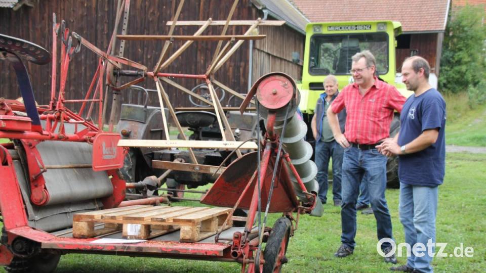 Einen solchen Bindemäher, Jahrgang 1958, kannte Bürgermeister Martin Prey (Zweiter von rechts) noch aus seiner Kinder- und Jugendzeit. Bild: frd