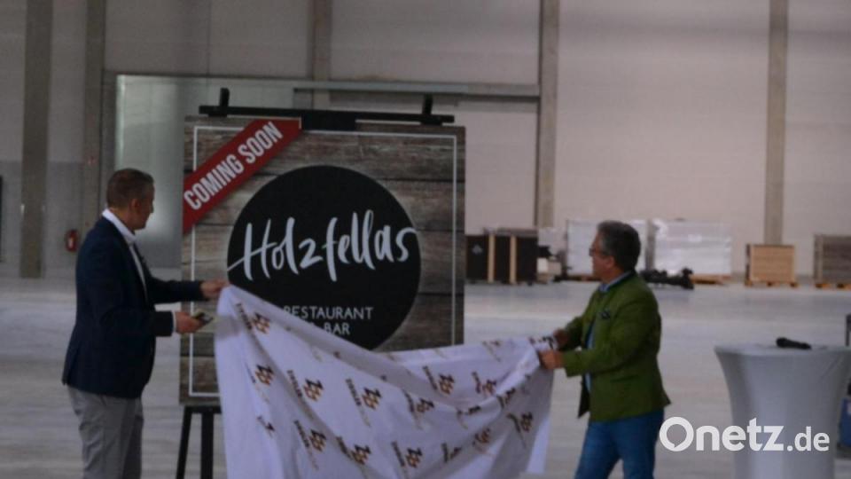 Prokurist Michael Wachsmann und Bürgermeister Toni Dutz (von links) enthüllten den neuen Namen des Restaurants in Wiesau: &quot;Holzfellas&quot;. Bild: rti