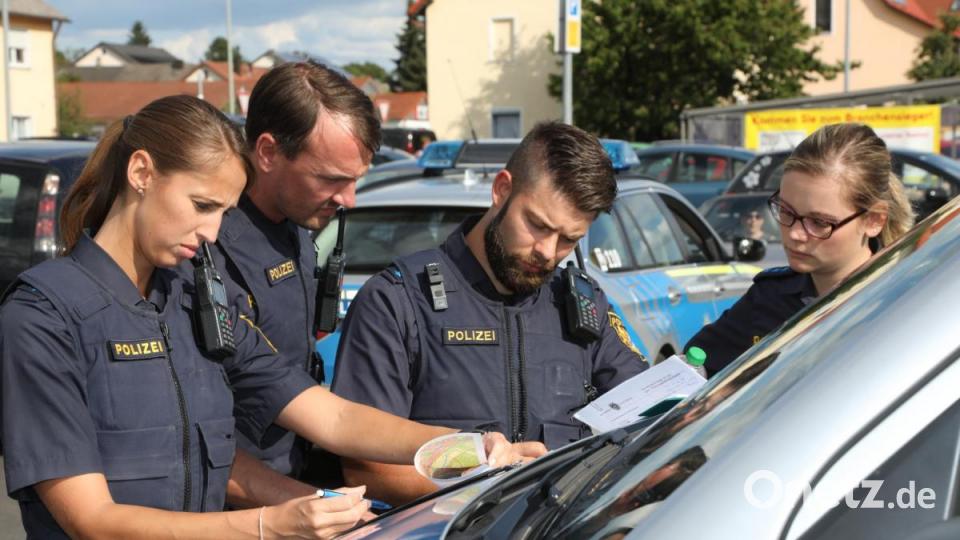 Am Parkplatz eines Supermarktes besprachen Polizisten den Einsatz. Bild: Wolfgang Steinbacher