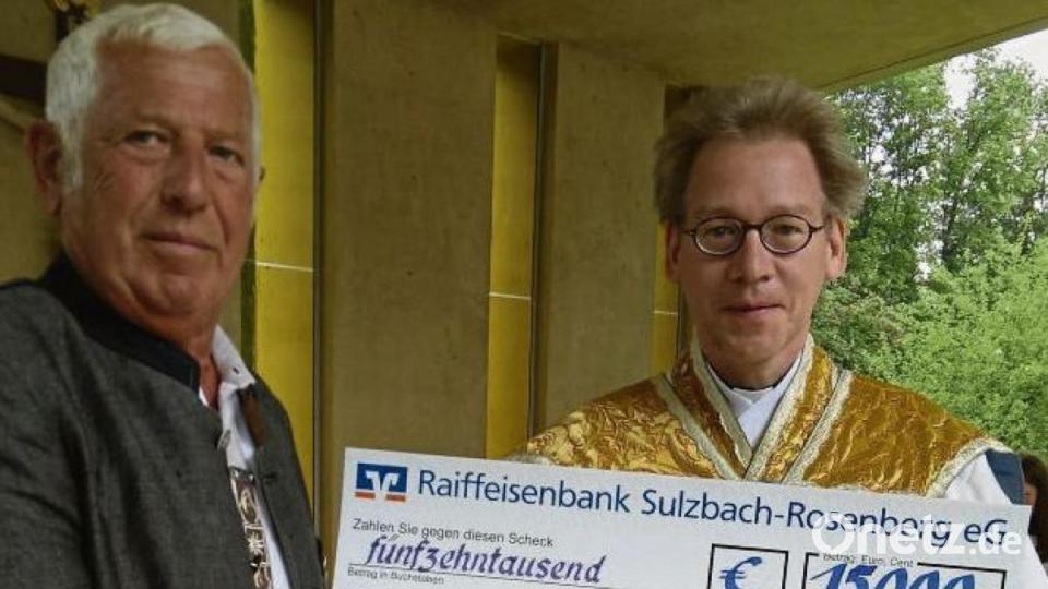 Franz Erras überreicht Pfarrer Schulz einen 15 000- Euro-Scheck. Bild: mma